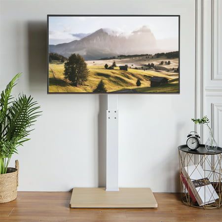 a flat screen tv sitting on top of a wooden table next to a potted plant