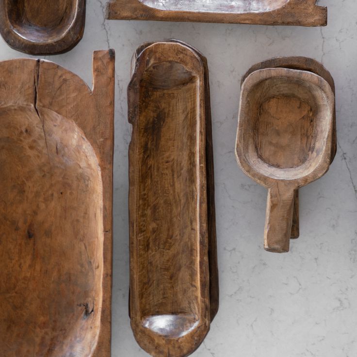 wooden spoons and bowls are lined up on a table