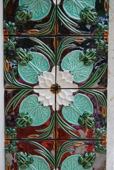 an artistic tile design with green leaves and flowers