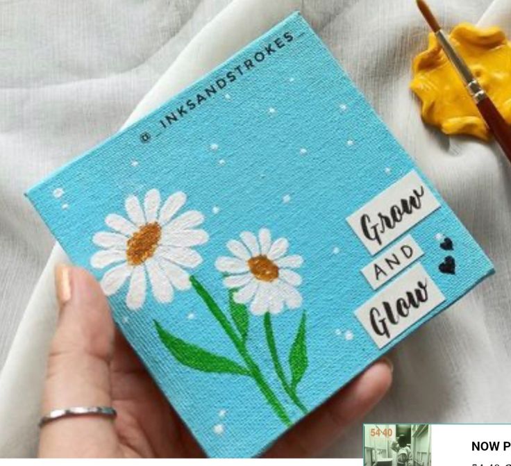 someone is holding up a card with daisies on it and the words grow and glow painted on it