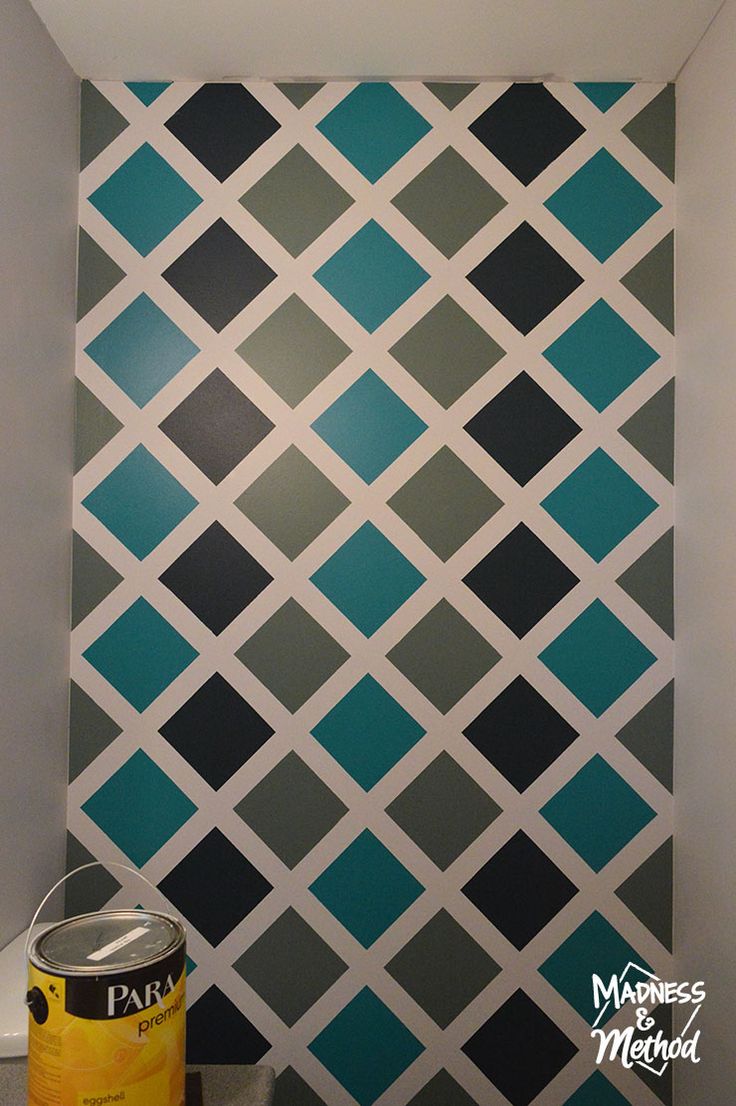 a wall painted with blue and grey squares in a bathroom next to a can of paint