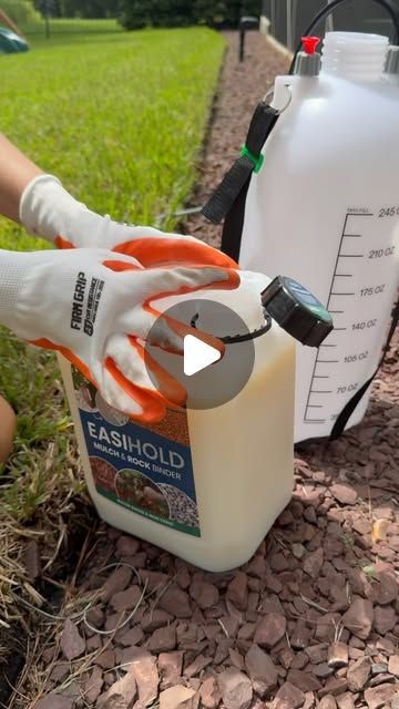 a person in white gloves holding a gallon of liquid