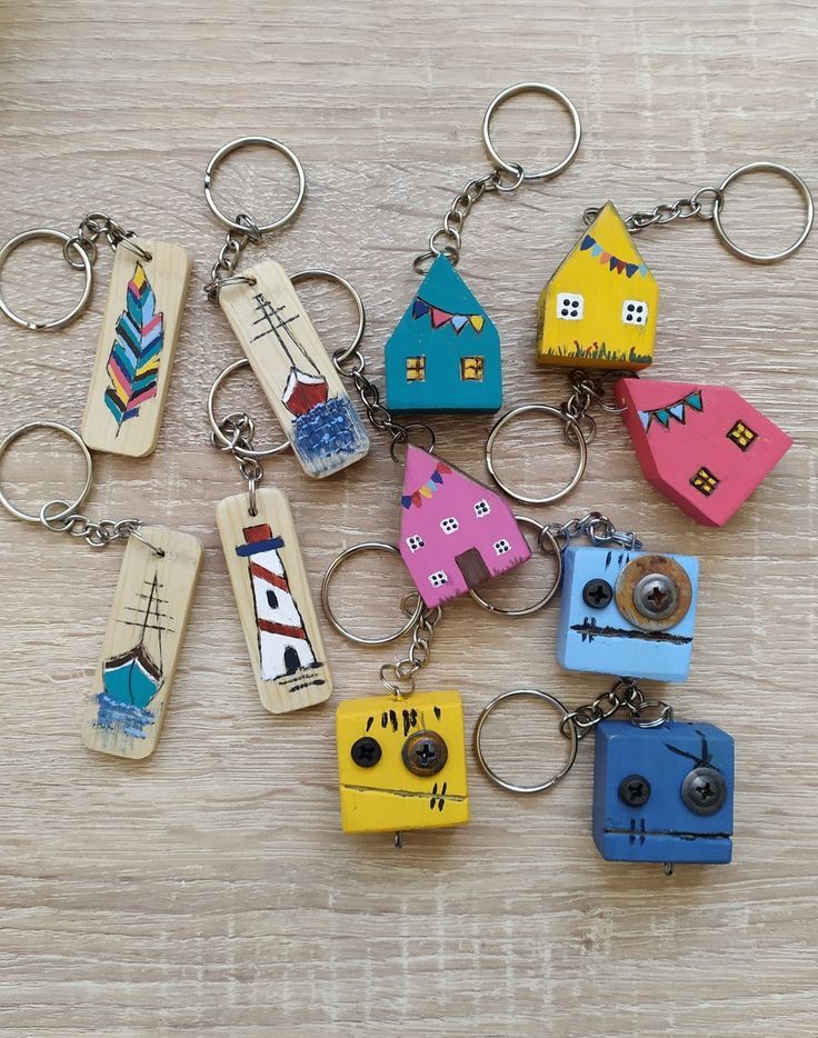 a bunch of wooden key chains that are on top of a wood table with different designs