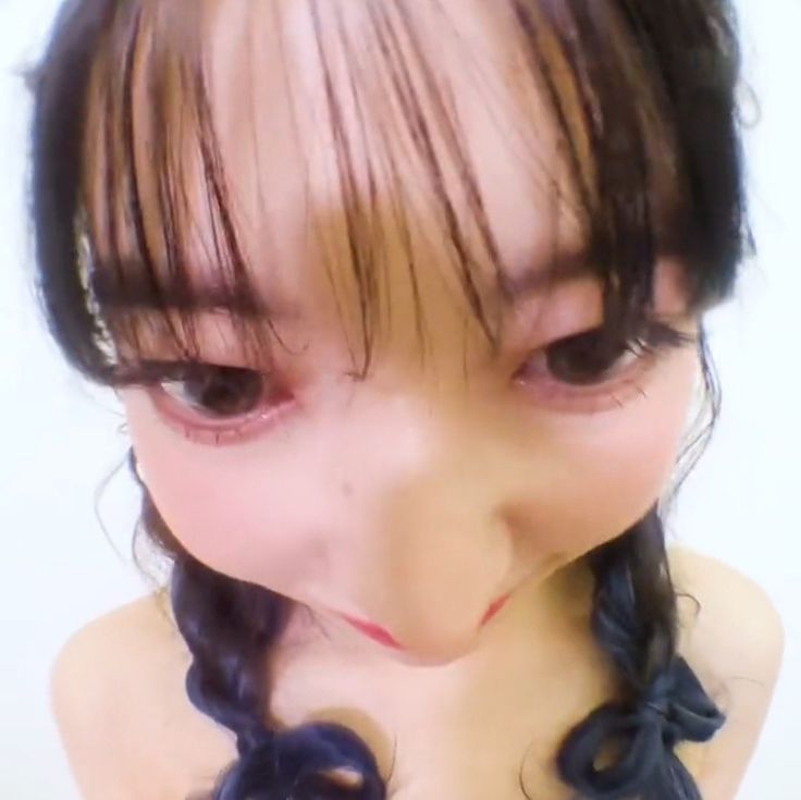 a close up photo of a doll with long hair and braids on her head