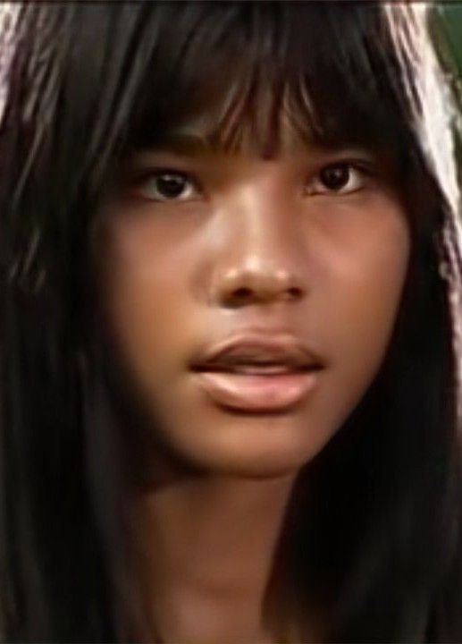 a close up of a woman with long black hair and an intense look on her face