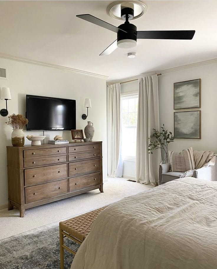 a bed room with a neatly made bed and a flat screen tv on the wall