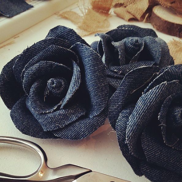 two black roses sitting on top of a table next to scissors