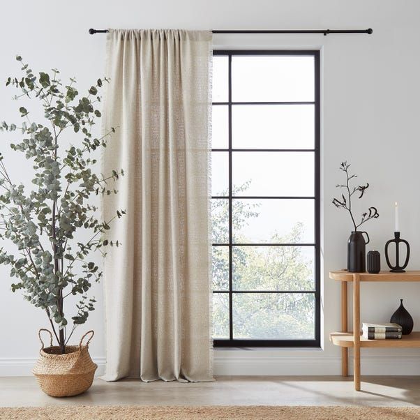 a living room with a large window and a potted plant