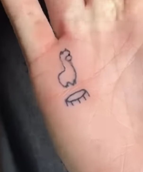 a person's hand with a small tattoo on it