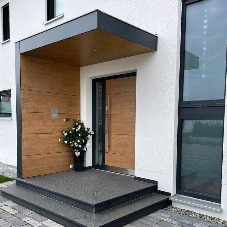 an entrance to a building with flowers in the vase on the step and glass windows