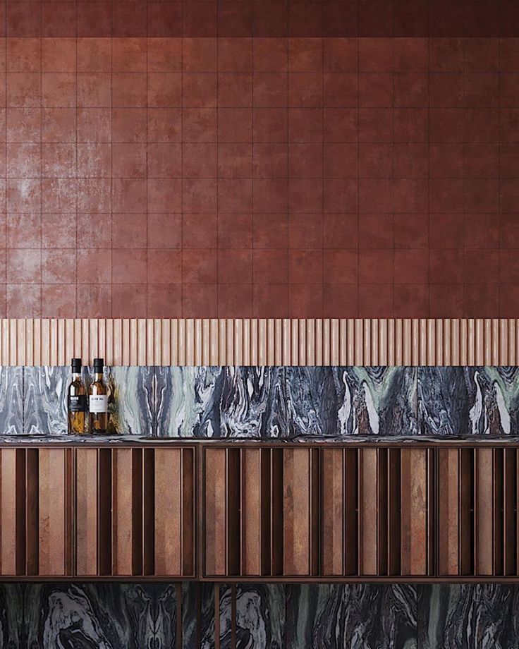 two bottles are sitting on top of the counter next to each other in front of a tiled wall