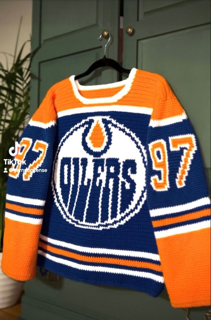 an orange and blue hockey sweater hanging on a hook