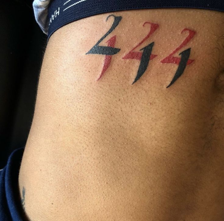 a man with a tattoo on his stomach has the number twenty four in red and blue