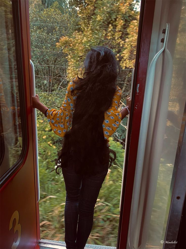 a woman is walking out the door of a train