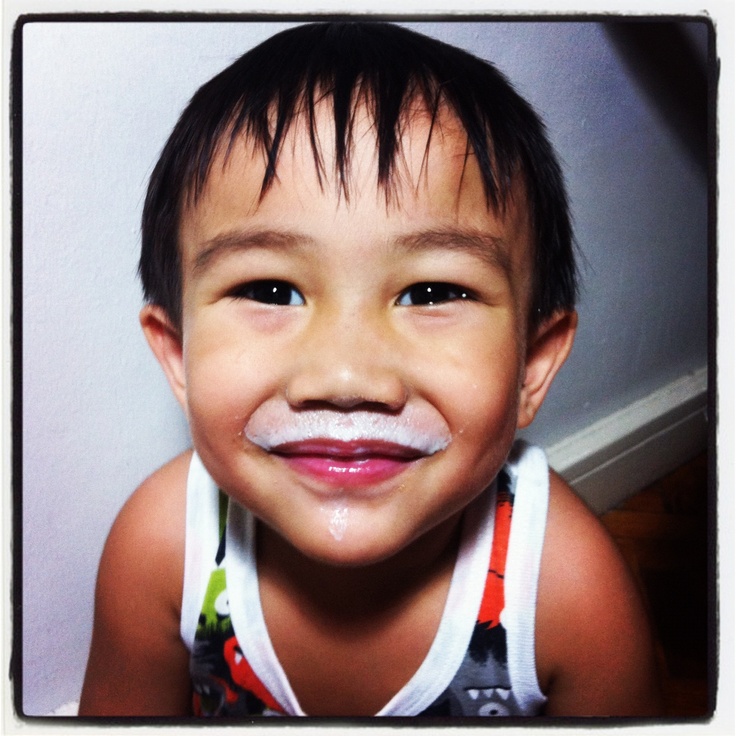 a young boy with a fake moustache on his face