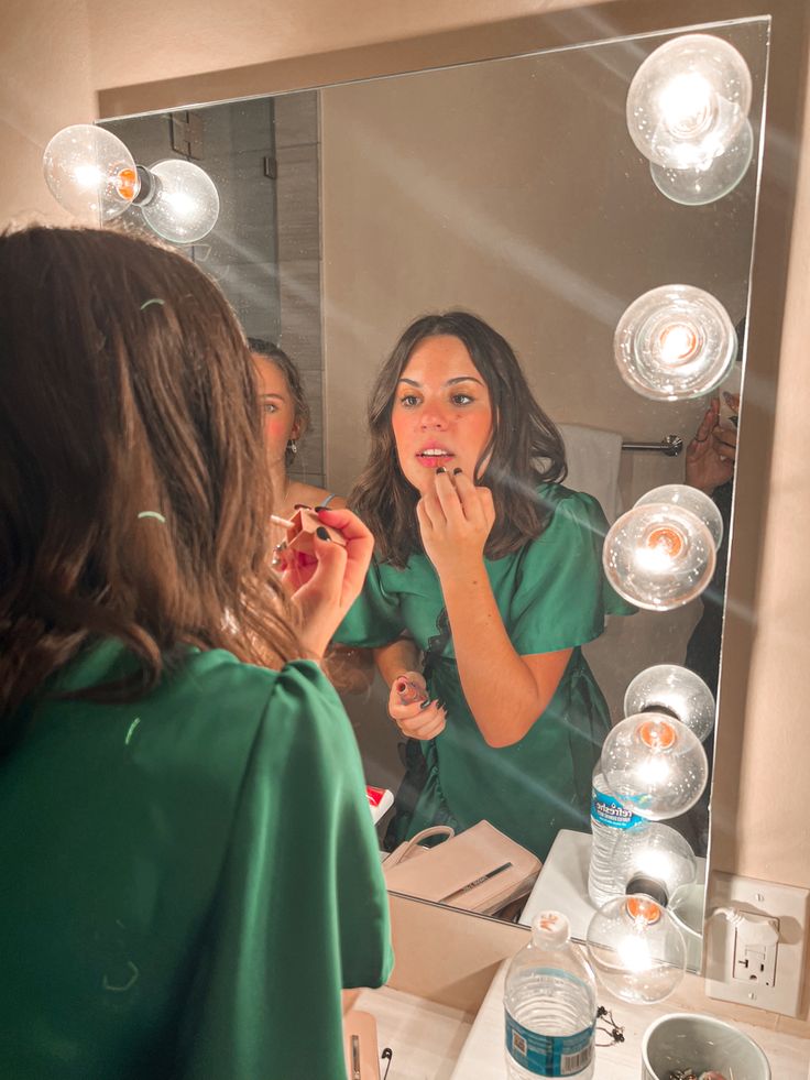 a woman brushing her teeth in front of a mirror with bubble lights on the wall