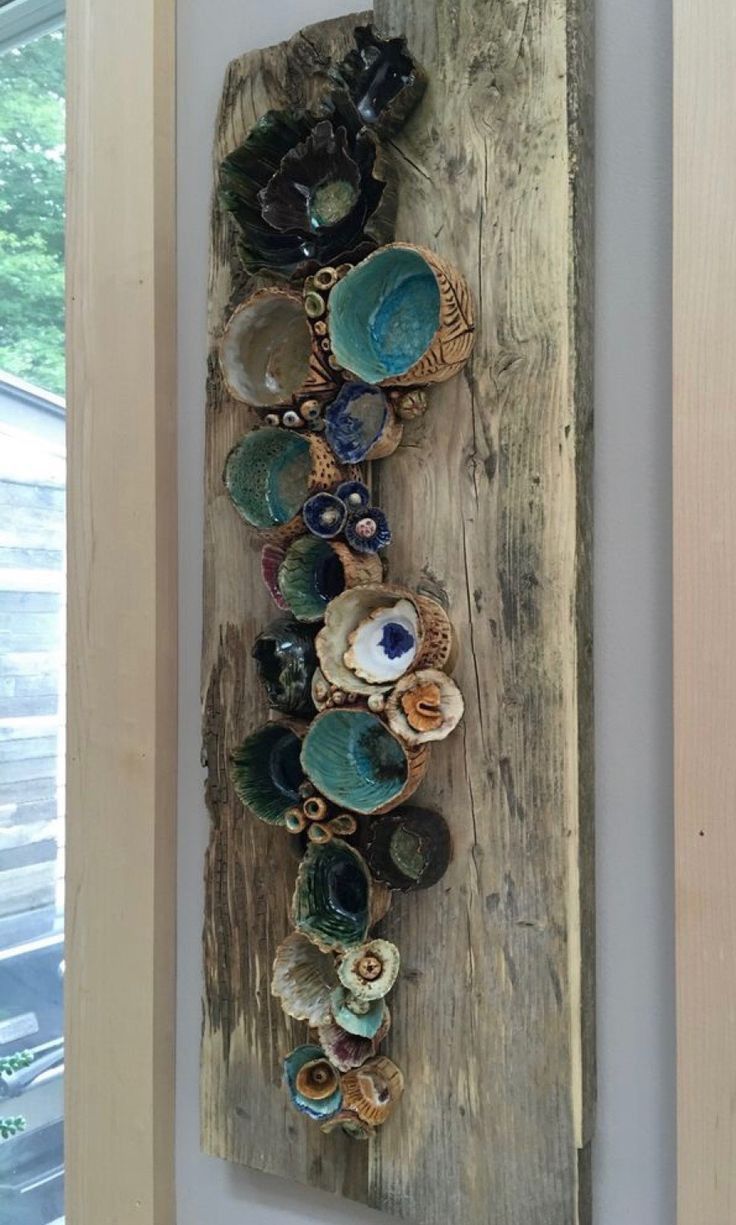 a wall hanging made out of wood with shells and seashells on the bottom