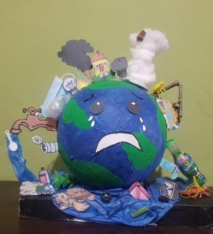 a blue and green globe with an angry face surrounded by other items on top of it