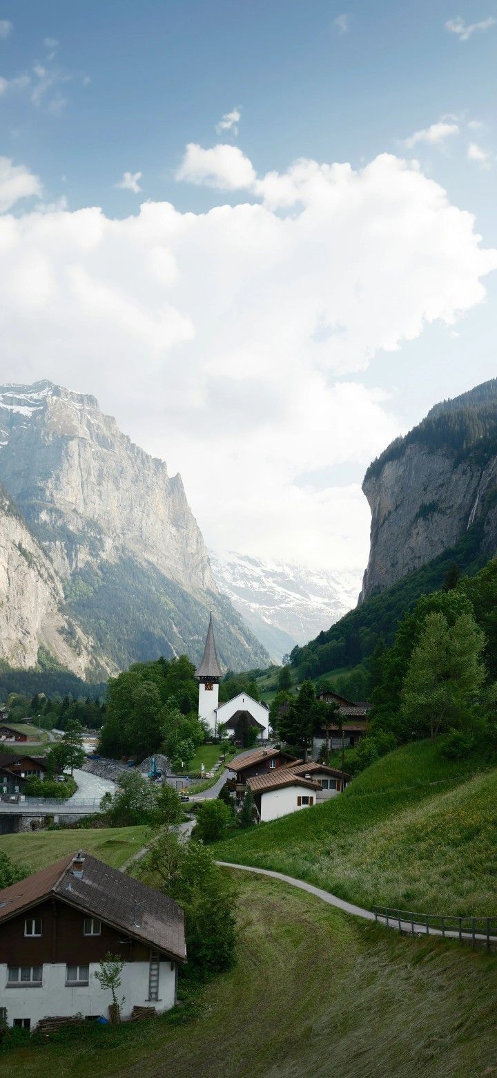 a small village in the middle of a valley with mountains in the backgroud