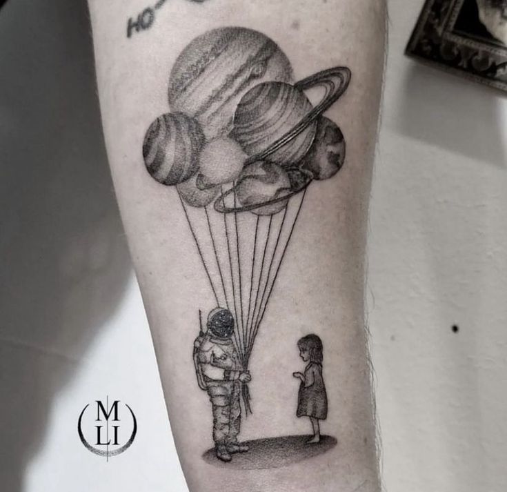 a man with a tattoo on his arm holding onto a balloon