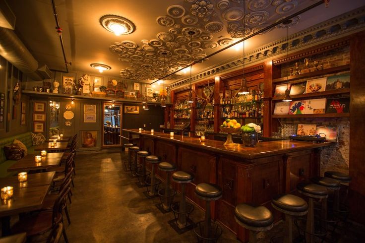 a dimly lit bar with lots of stools and lights on the ceiling above it