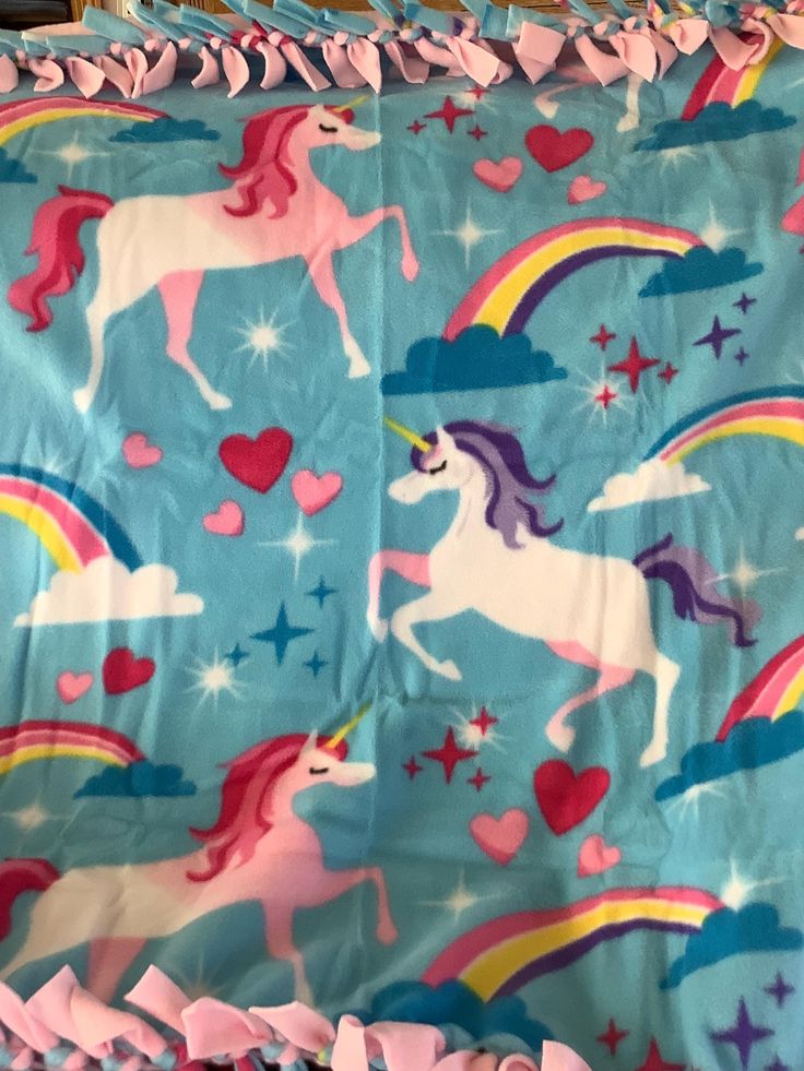 this is an image of a bed sheet with unicorns and hearts on blue background