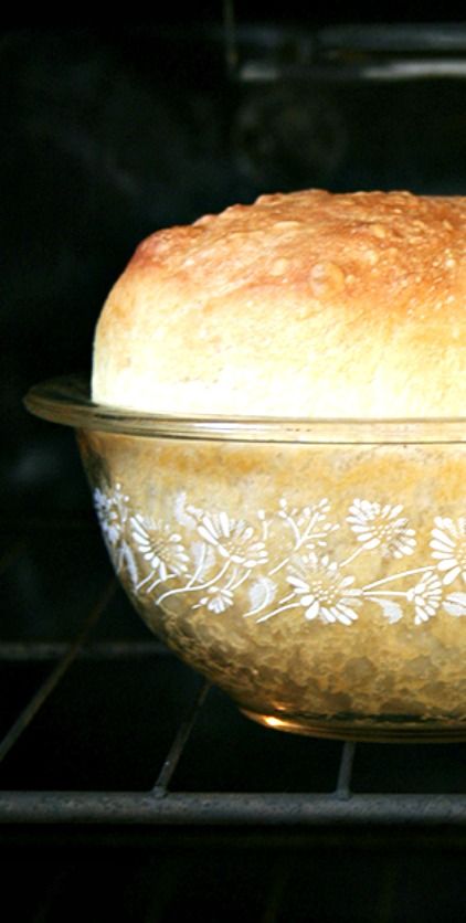 a loaf of bread sitting in an oven on top of a glass dish with floral designs