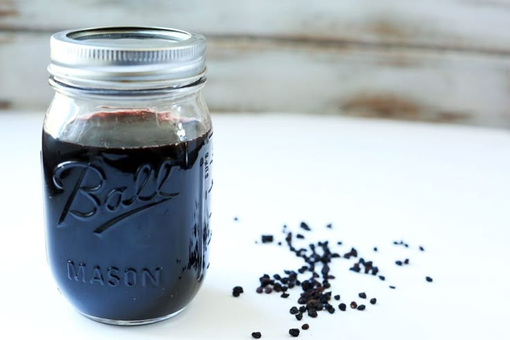 a mason jar filled with black seeds on top of a table