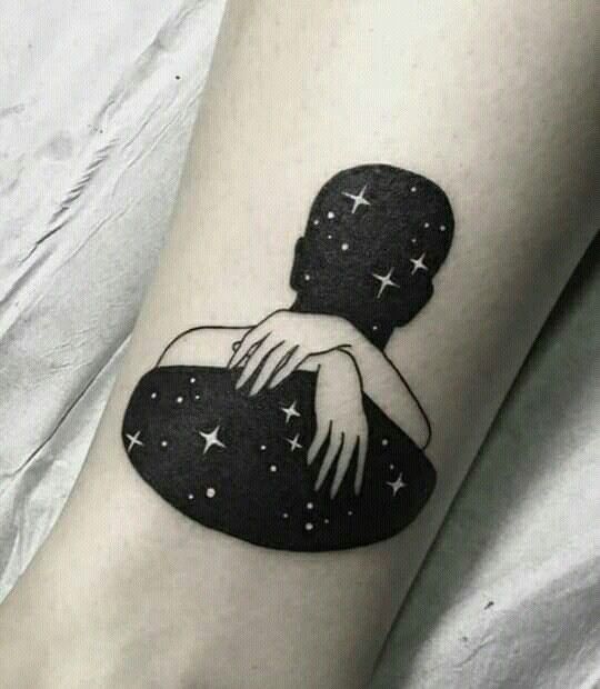 a black and white photo of a woman's arm with stars in the background