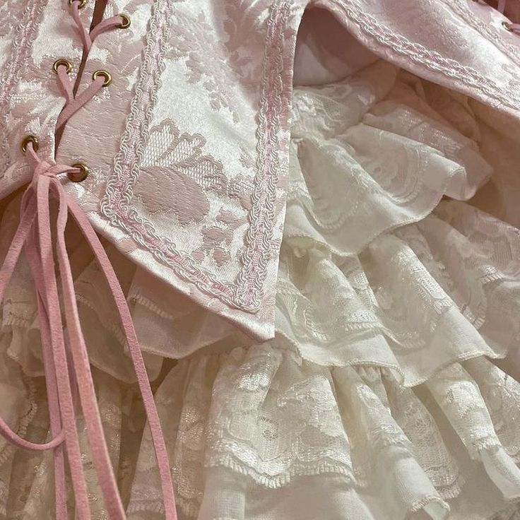 the dress is pink and white with lace on it