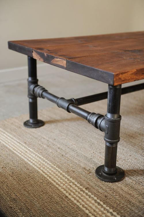 a wooden table with pipes on it sitting on top of a carpeted floor next to a wall