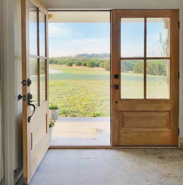 an open door leading to a large grassy field