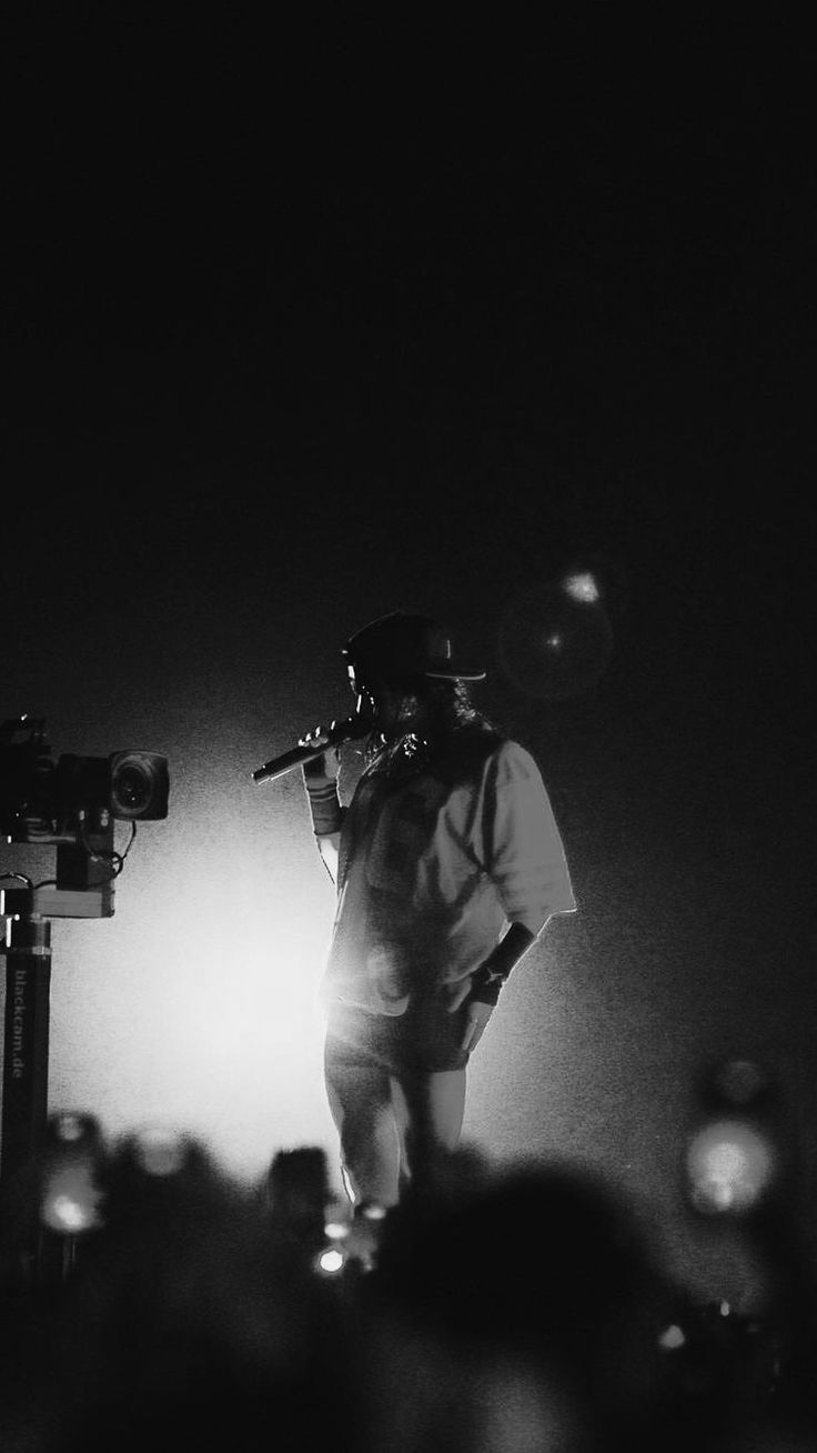 a man standing on top of a stage next to a microphone in front of a crowd