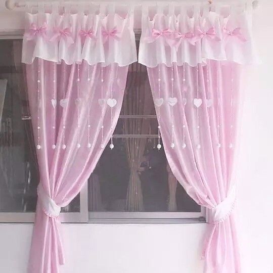 the window is decorated with pink curtains and hearts on it's valances