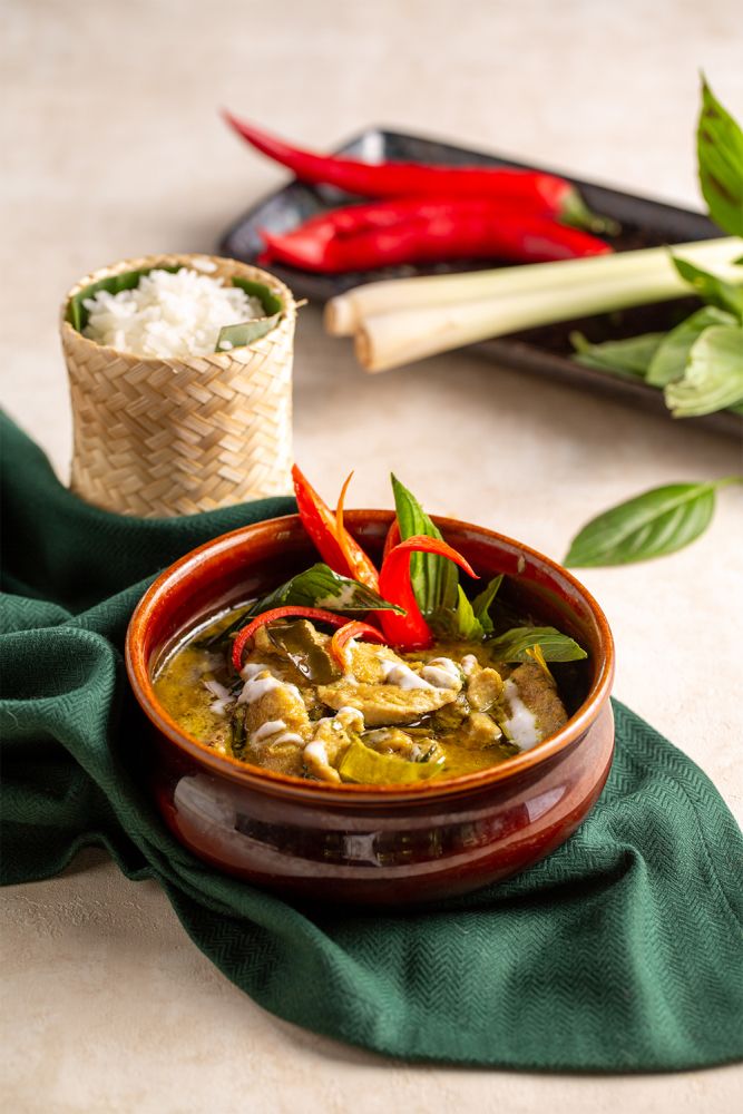 a bowl filled with food sitting on top of a green cloth next to chopsticks