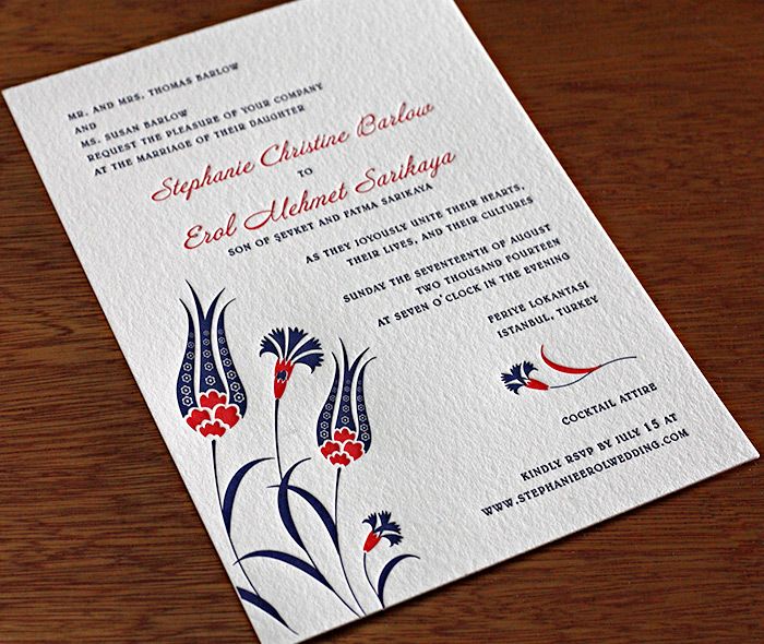 an ornate wedding card with red and blue flowers on the front, in white paper