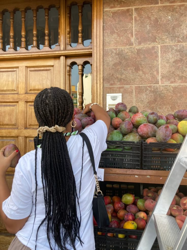 a woman is picking out some fruit at the market