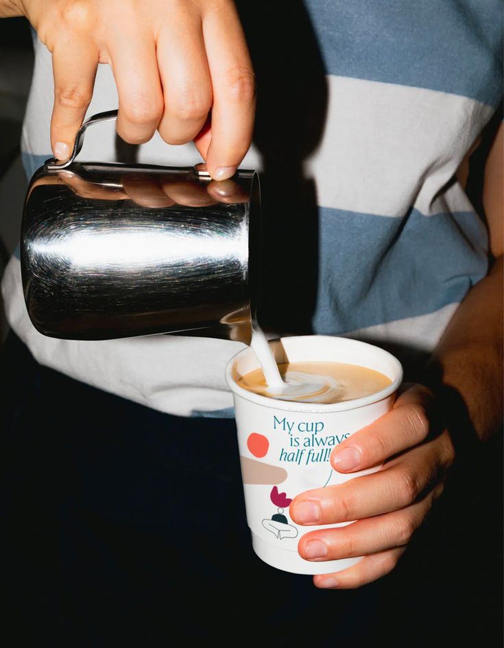 a person pouring coffee into a cup