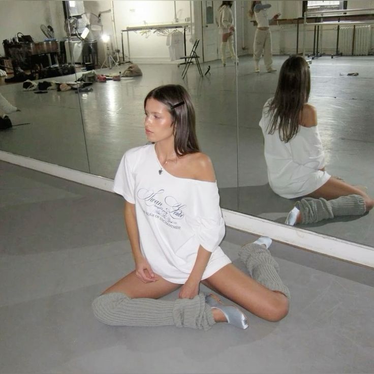 two women sitting on the floor in front of a mirror