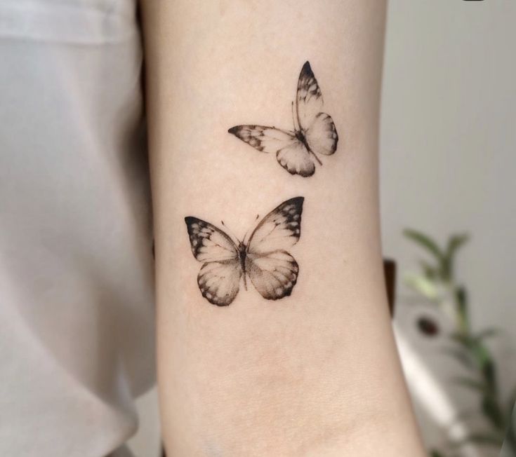 two small butterflies on the wrist tattoo design for girls and women, one is black and white