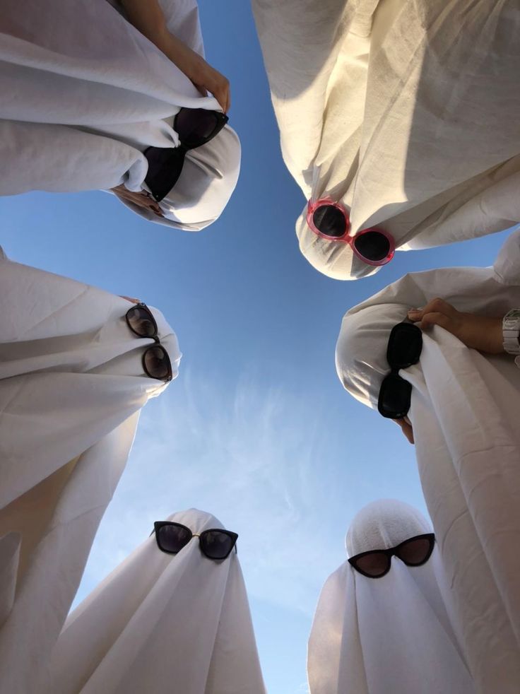 several people in white cloths with sunglasses on