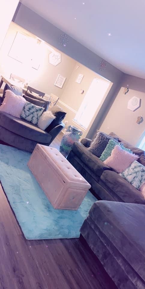 a living room filled with lots of furniture on top of a hard wood floored floor