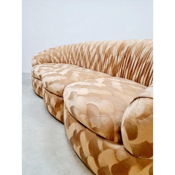 a large couch sitting on top of a floor next to a white wall with an animal print pattern