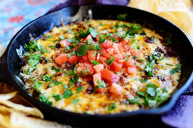 a black pan filled with food next to tortilla chips and a purple towel