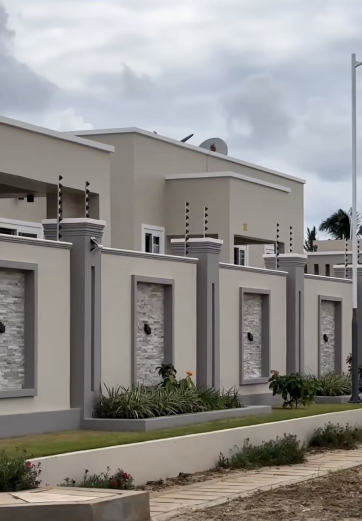 a row of houses sitting next to each other on a cloudy day with palm trees in the background