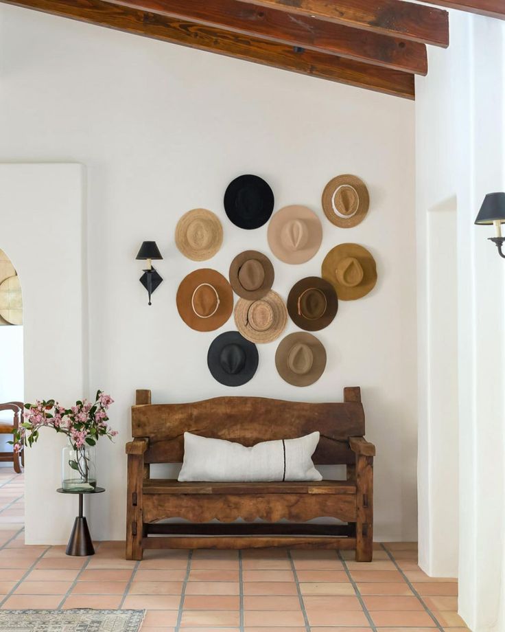 a room with hats on the wall and a wooden bench