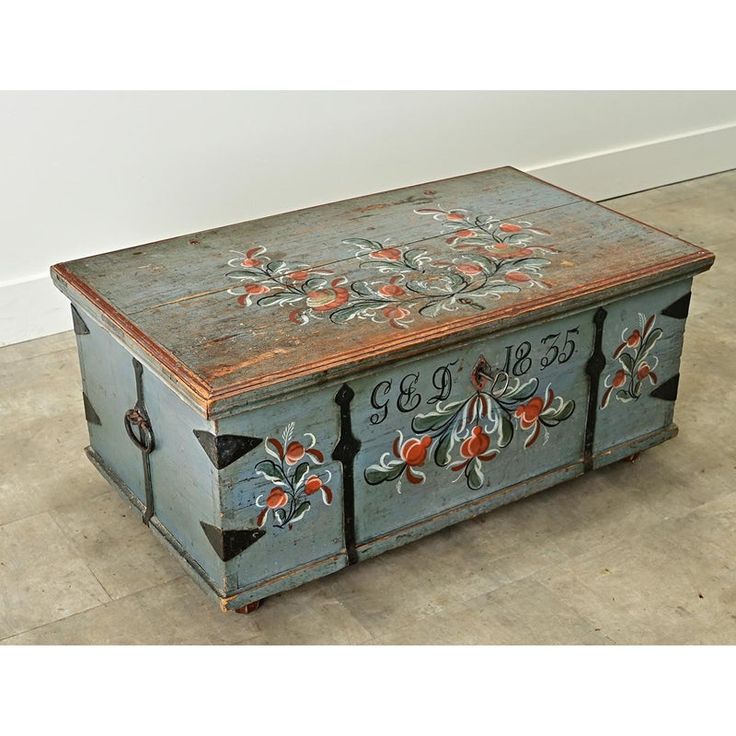 an old wooden box with painted flowers on it