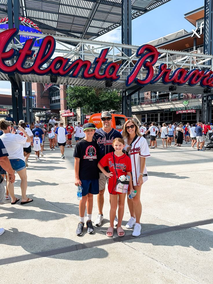 two children and an adult standing in front of the cleveland braves baseball team's arch