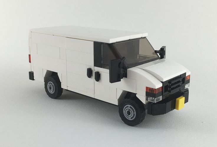 a lego model of a white truck on a white surface with the door open and windows closed