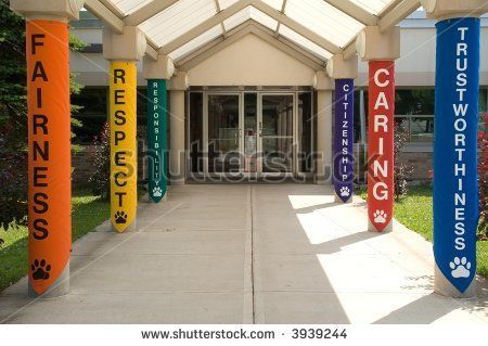 an entrance to a building with many colorful signs on the front and side columns that say caring